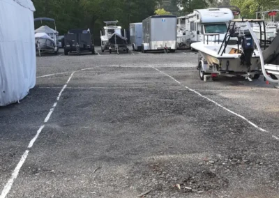 A boat on a trailer is parked in a storage lot at Matthews Boat and RV Storage.